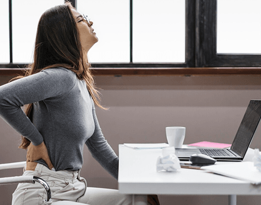 Femme qui a mal au dos à son poste de travail